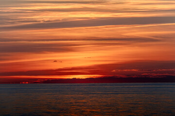 The beautiful sun is setting gracefully over a tranquil body of water