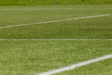 Obraz premium Football field with synthetic grass, with an angle below, highlighting the green of the lawn and some white lines.