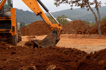 Excavator bucket digs earth on construction site. Excavator bucket close up. House construction....