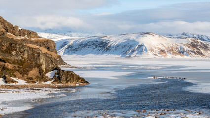 Wonderful Icelandic landscape near Reynisfjara beach. Water surrounded with ice, rocks at the side...