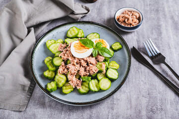 Keto salad with tuna, cucumber, egg and basil in a bowl on the table