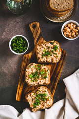 Bruschetta with mashed white beans and parsley on rye bread on a board top and vertical view