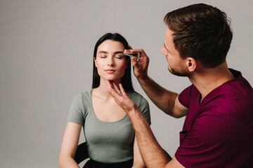 Blepharoplasty marking up. Plastic surgeon is measuring distance in between marking lines for well planned blepharoplasty. Using Castroviejo caliper to draw symmetrical contour for eyelid surgery.