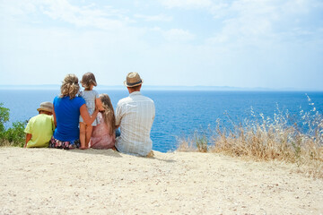 A happy family taking a selfie by the sea on a trip