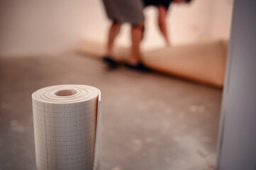 Close-up of Rolled Flooring Underlay with Person in Background