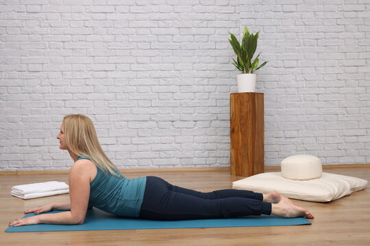 Woman doing yoga in yoga studio - Half Cobra