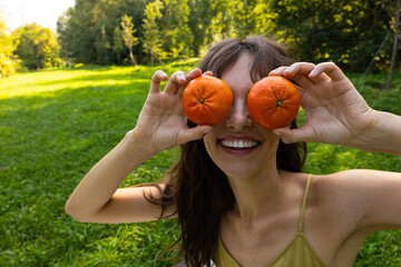 Beautiful curly smiling woman with fresh mandarins