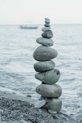 pyramid of stones against the backdrop of the sea at sunset
