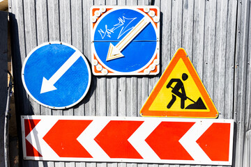 Different road signs on the iron fence