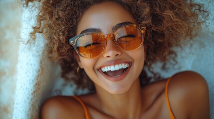 Smiling woman with curly hair enjoying a sunny day while wearing stylish sunglasses outdoors in a relaxed setting