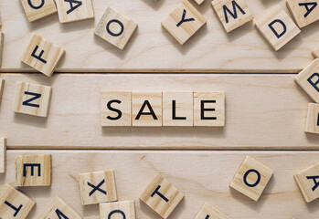 A wooden board with a jumble of letters and the word Sale written in the middle