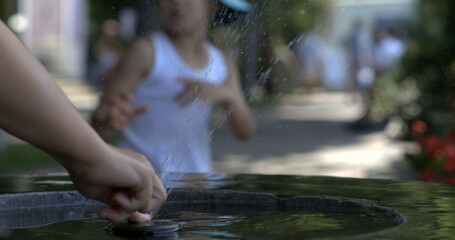 Child playing with water fountain in slow motion at 800 fps, capturing the joy and fun of splashing water on a bright, sunny day