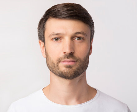 Passport Photo. Portrait Of Middle Aged Man Looking At Camera Over White Studio Background. Isolated