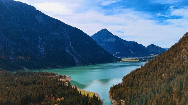 Beautiful scenery of a lake among the mountains covered with pine trees. Aerial view of Lake Plansee in Tyrol, Austria in the Alps.