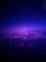 blue  and pink sky with clouds from a plane window