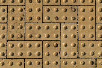 tactile tiles for the visually impaired on a pedestrian path, closeup photo