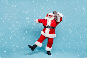 Full length body size view of his he nice cool fat cheerful cheery glad excited carefree bearded Santa clubber carrying tape player dancing clubbing isolated on blue turquoise pastel color background © deagreez