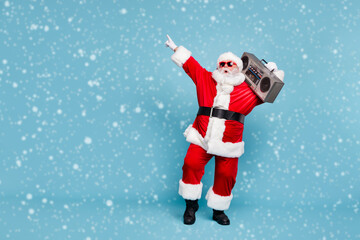 Full length body size view of his he nice cool trendy stylish fat cheerful cheery glad excited bearded Santa carrying tape player dancing isolated over blue turquoise pastel color background © deagreez