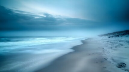 Obraz premium A long exposure photograph of the beach. The ocean is calm and blue, with some fog on top