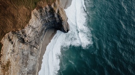 An aerial view of majestic coastal cliffs overlooks crystal clear waters where the land meets the...