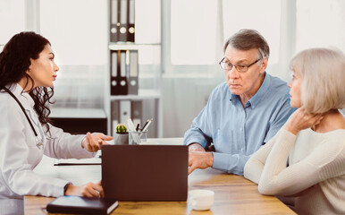 Medical Test Results. Brazilian doctor pointing at digital tablet, explaining diagnosis to senior couple, copyspace