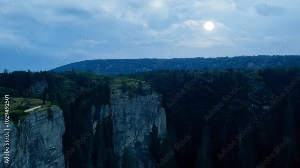 Poster the full moon is rising over a dramatic cliff edge and a forest in the valley below. the moon is ill