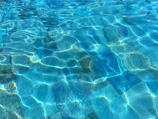 The water in the pool shimmers in the sun. The blue texture of the pool water