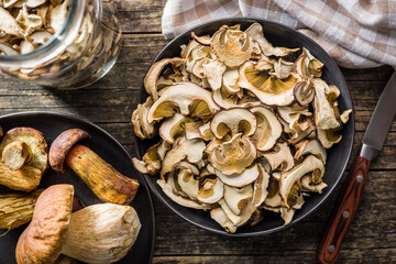 Dried porcini mushrooms. Sliced boletus on plate on wooden table. Top view.