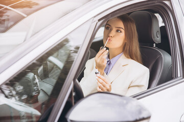 Stylish Woman Applying Lipstick Inside a Modern Car