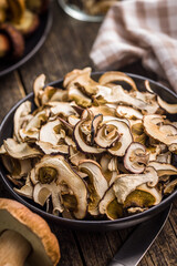 Dried porcini mushrooms. Sliced boletus on plate on wooden table.