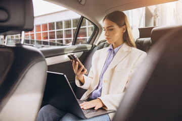 Young Businesswoman Working Efficiently in Car with Laptop