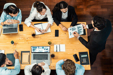 Panorama top view diverse group of business analyst team analyzing financial data report paper on meeting table. Chart and graph dashboard by business intelligence analysis. Meticulous