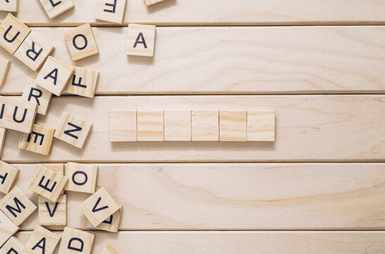 Wooden board with a jumble of letters and a word written in the middle