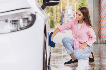 Young Woman Washing Car with Blue Cloth at Self-Service Station