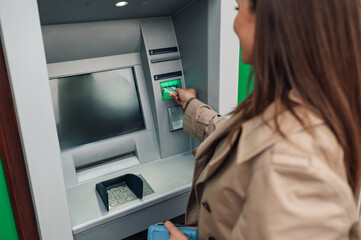Businesswoman withdrawing money from atm in the city