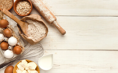 Cooking ingredients background. Border of flour, eggs, raisins, sugar, milk, butter and kitchen...