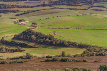 Obraz premium A view of beautiful, peaceful farmland, interspersed with trees and rolling terrain.