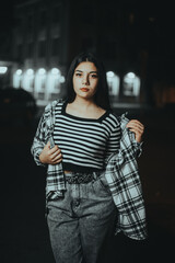 Chic Brunette Posing Near Theater at Night