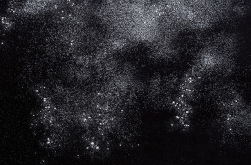 Abstract background. Wheat flour spots on black. Top view on blackboard. Baking concept, cooking dough or pastry.