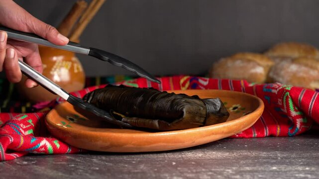 Banana leaf tamales, placing a jarocho tamale on a clay plate