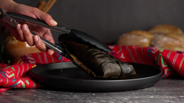 Banana leaf tamales, placing a jarocho tamale on a black plate