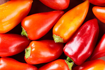 Vibrant Red and Orange Bell Peppers on Brown Background, Close-Up