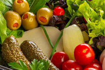 Close-up Tropical salad containing iceberg lettuce, mint, mango, leek and cherry tomatoes on a white marble background