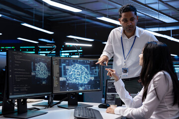 Teamworking professionals working on PC in data center with artificial intelligence tech. Coworkers doing brainstorming, solving tasks in server hub storing data used for deep learning