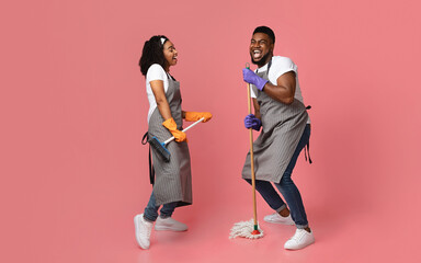 Joyful Housekeeping Concept. Portrait Of Cheerful African Couple Of Cleaners Having Fun During Chores