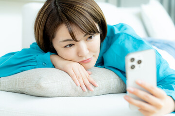 リビングでスマホを操作する女性