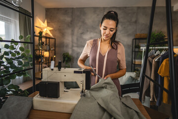 Adult woman fashion designer or tailor hold scissors cut textile