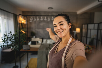 Self portrait of adult woman tailor show her workshop