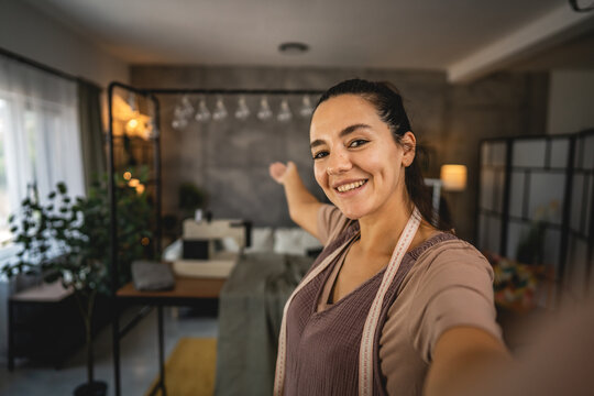 Self portrait of adult woman tailor show her workshop