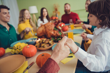 Photo of happy big family celebrating thanksgiving day festive vent together praying appreciating eating lunch indoors